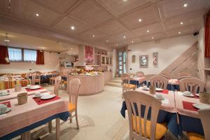 een restaurant met tafels en stoelen en een keuken bij Garni Oasi in Livigno
