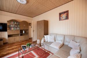 a living room with a couch and a table at Vadkacsa apartmanház medencével in Zamárdi