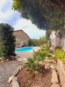 a swimming pool in a yard with a house at La maisonnette avec SPA, PISCINE et CLIMATISATION in Sainte-Vallière