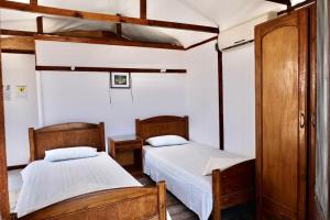 マルサー・アラムにあるBedouin Valley Eco Resortの白い壁とウッドフロアの客室で、ベッド2台が備わります。