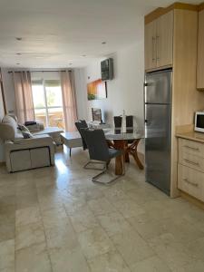 cocina con nevera y mesa con sillas en Apartamento Aguadulce Plaza Caribe, en Aguadulce