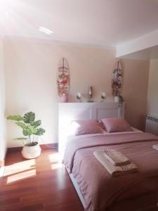 um quarto com uma cama e um vaso de plantas em Villa Armanbel em Sesimbra