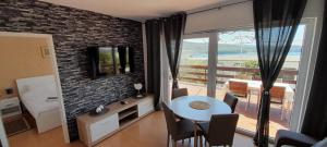 een woonkamer met een tafel en een kamer met een balkon bij Apartments Borić in Cres