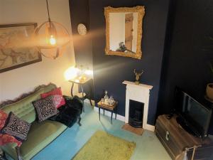 a living room with a couch and a fireplace at BohemianBreezeBreaks in Thornton Dale