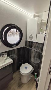 ein kleines Bad mit einem WC und einem runden Fenster in der Unterkunft Houseboat Water Boy apartament pływający dom na wodzie łódź in Breslau
