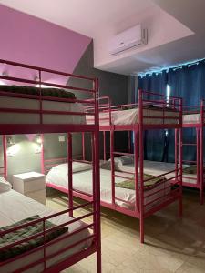 a room with three bunk beds in it at Lion Hostel in Milan