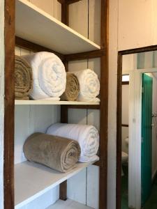 a shelf with rolls of towels on it at Caraguatás in Cunha