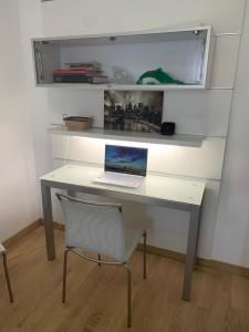 a desk with a laptop on it with a chair at La maison Lillà, Sabaudia in Sabaudia +23 photos