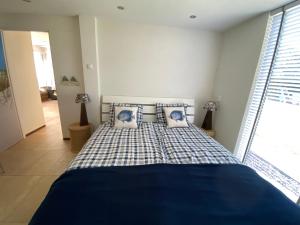 Un dormitorio con una cama azul y blanca con almohadas en Vakantiebungalow Mee naar Ouddorp aan zee, en Ouddorp