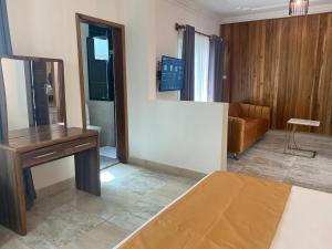 达喀尔滨海路酒店的一间有一张床、一张桌子和一张沙发的房间