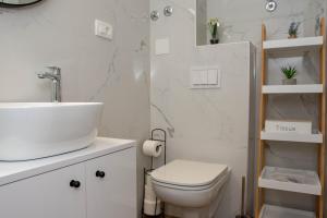 uma casa de banho branca com um lavatório e um WC em Luxury Rooms Rustic Chic em Split