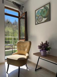 una sedia e un tavolo in una stanza con finestra di Rebus Apartments a Sandanski