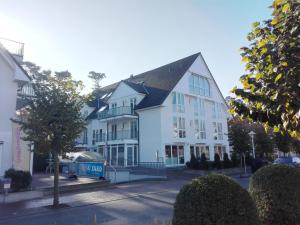 a large white building with a black roof at Ferienwohnung Meeresleuchten in Baabe