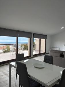 a living room with a white table and chairs at Apartamentos Las Huertas in Villamiel