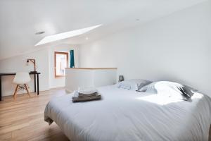 a white bedroom with a large white bed and a table at Dominici 1-CahorsCityStay-Centre Clim Netflix in Cahors
