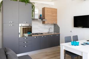 a kitchen with gray cabinets and a white table at Antonio Busco rooms in Turi