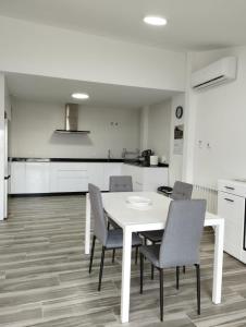 a dining room with a white table and chairs at Apartamentos Las Huertas in Villamiel