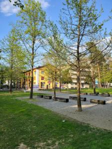 una fila de bancos en un parque con árboles en GuestHouse University by LR - self check in en Lugano