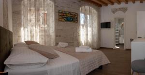 um quarto com uma cama grande e almofadas brancas em Luxury Rooms Rustic Chic em Split