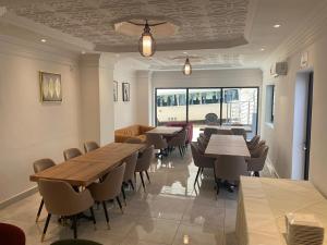 a dining room with tables and chairs and a window at Hotel Residence La Corniche in Dakar