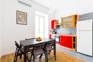 kuchnia z czarnym stołem i czerwonymi szafkami w obiekcie Barrio 133 - double bedroom in center by Napoliapartments w mieście Neapol