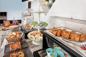 un buffet con muchos tipos diferentes de pan y repostería en B&B A casa di Aurora rooms, en San Vito lo Capo