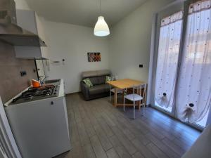 eine Küche und ein Wohnzimmer mit einem Tisch und einem Sofa in der Unterkunft Appartamento Tramontana in Deiva Marina