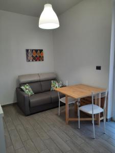 ein Wohnzimmer mit einem Sofa und einem Tisch in der Unterkunft Appartamento Tramontana in Deiva Marina