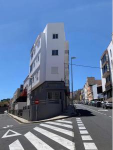 a tall white building on the side of a street at Salud Vacacional in Santa Cruz de Tenerife