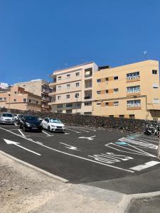 a parking lot with cars parked in front of a building at Salud Vacacional in Santa Cruz de Tenerife