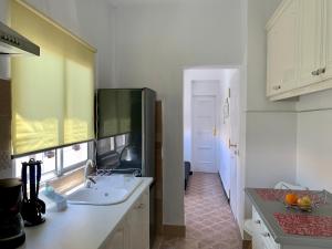 a white kitchen with a sink and a counter at Salud Vacacional in Santa Cruz de Tenerife