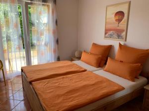 ein Schlafzimmer mit einem großen Bett mit einer orangefarbenen Decke in der Unterkunft Atempause in Kirchdorf