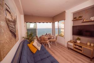 a living room with a blue couch and a table at Bow Sea Apartment in Algarrobo-Costa