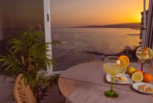 Bow Sea Apartment في ألغاروبو - كوستا: طاولة مع كوب من النبيذ وإطلالة على المحيط