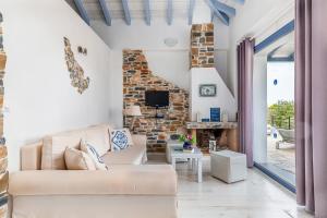 a living room with a couch and a fireplace at Villa Galazopetra in Skopelos Town