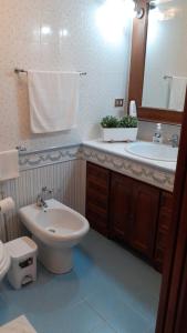 a bathroom with a sink and a toilet and a mirror at Casa Vacanze Chiara in Terrasini