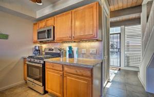 a kitchen with wooden cabinets and a stove top oven at OCEAN VIEW 2 BEDROOM DOWNTOWN CONDO condo in Kailua-Kona +42 photos