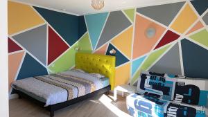 a childs bedroom with a colorful geometric wall at Appartement Futuroscope-E' in Chasseneuil-du-Poitou