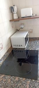 a microwave sitting on a counter in a kitchen at Santoña Paseo Marítimo 2ª linea playa, Llegada autónoma, Wifi in Santoña
