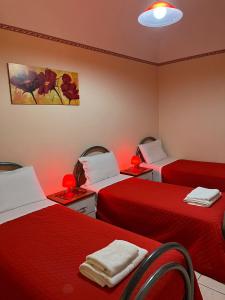 a room with two beds with red sheets at Albicocche House in Giarre
