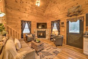 a living room with a couch and a fireplace at Charming Log Cabin at Double JJ Ranch Resort! in Rothbury