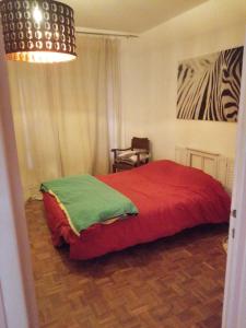 1 dormitorio con 1 cama con manta roja en La CAMPAGNE A LA VILLE, en Dijon