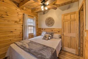 um quarto com uma cama e uma ventoinha de tecto em Charming Log Cabin at Double JJ Ranch Resort! em Rothbury