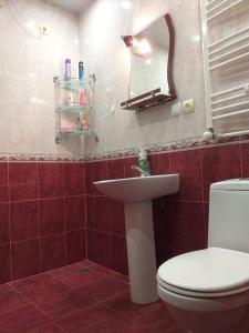 een badkamer met een toilet, een wastafel en een spiegel bij sweethouse in Tbilisi City