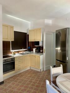 uma cozinha com armários de madeira e um frigorífico de aço inoxidável em Salud Vacacional 2 em Santa Cruz de Tenerife