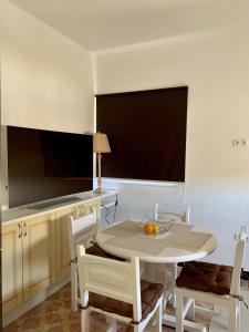 uma cozinha com uma mesa branca e cadeiras e uma mesa e uma mesa e cadeiras em Salud Vacacional 2 em Santa Cruz de Tenerife