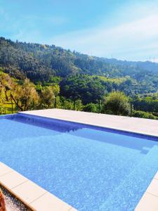 una piscina con una montaña en el fondo en Casa da Benda, en Caniçada