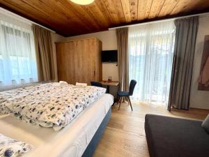 a bedroom with a large bed and a desk and window at Pension Sommerauer in Hallein