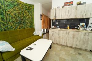 a living room with a green couch and a table at Nice suite Nahariyya in Nahariyya