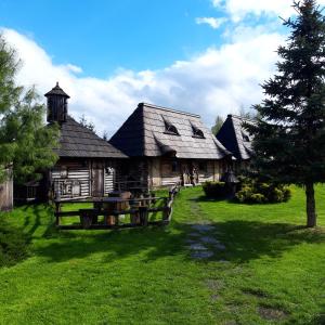 stary drewniany dom na polu zielonej trawy w obiekcie Gród Pędzików w Chęcinach